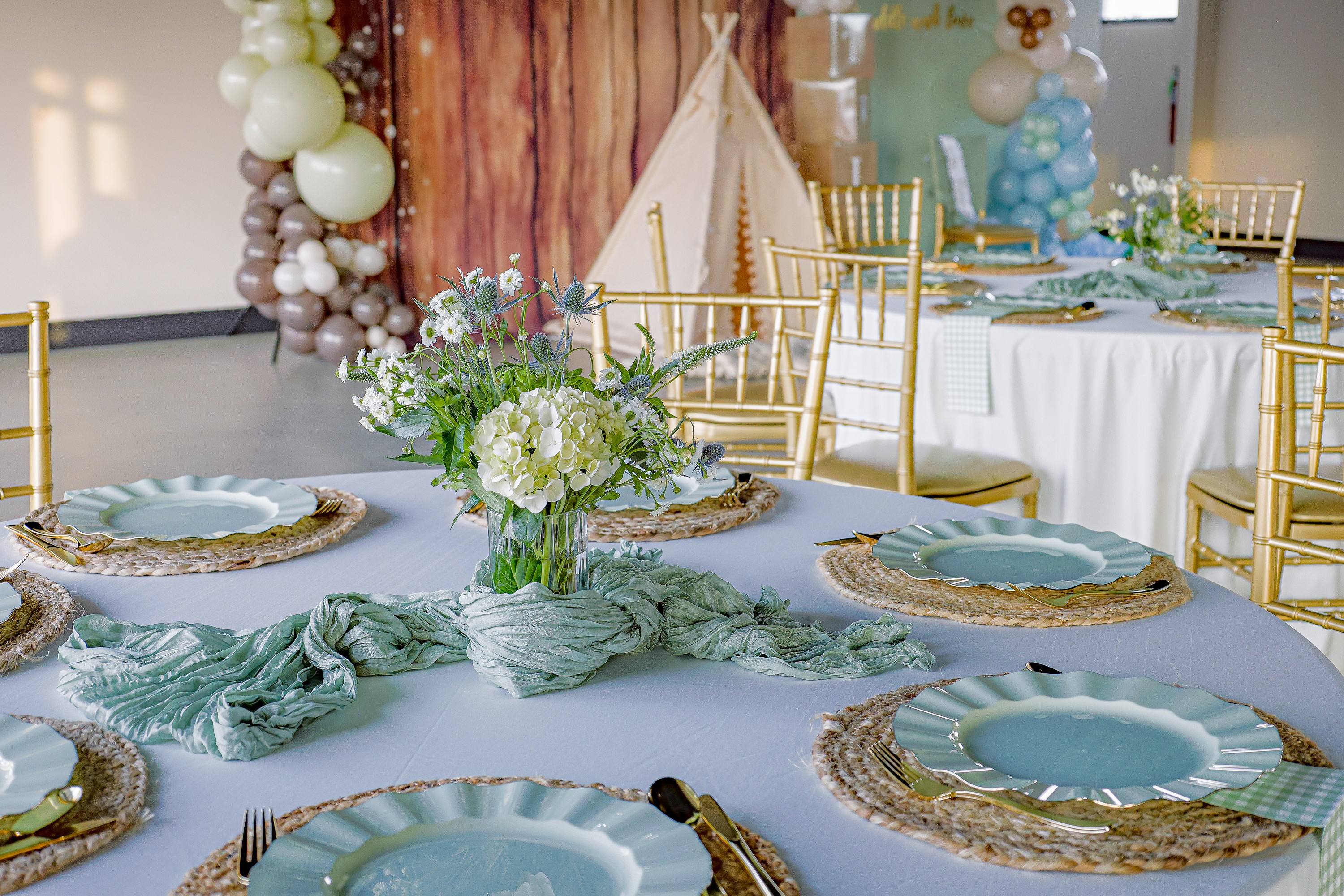 Sage green place settings with jute chargers and fresh florals